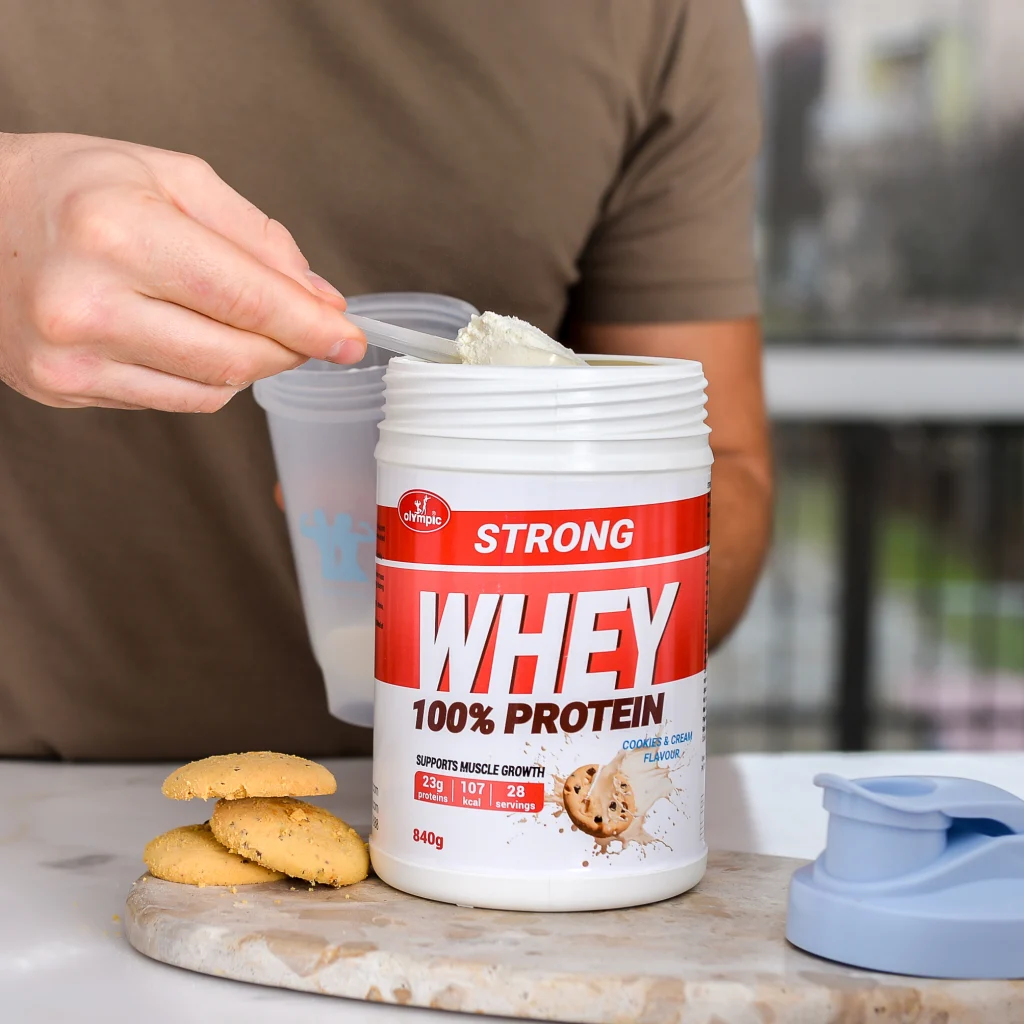 Muški model pokazuje pripremu šejka Olympic Strong Whey Proteina cookies&cream 840g